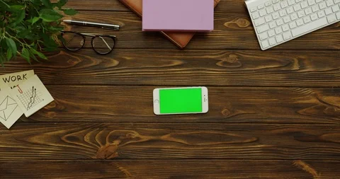 Top view on the white horizontal smartphone with a green screen on the wooden 스톡 동영상 88381386