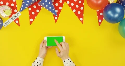 Top view on the white horizontal smartphone on the yellow table with birthday Stock Footage 89316352