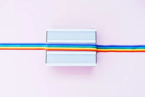Top view white light box mockup with rainbow LGBT ribbon on a light pink Stock Photos