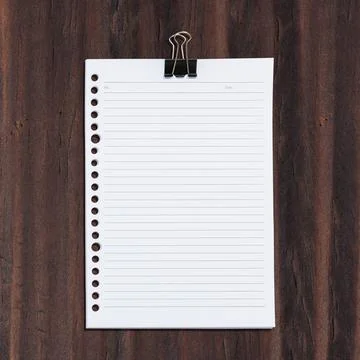 Top view of a white, lined paper sheet with hole punches on the left side, .. Stock Photos