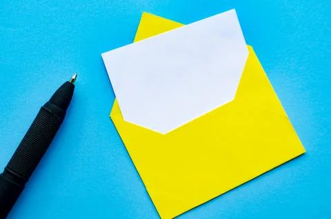 Top view of white notepad and pen with envelope on blue cover background wi.. Foto stock