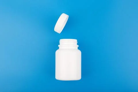 Top view of white opened medication bottle against blue background Stock Photos