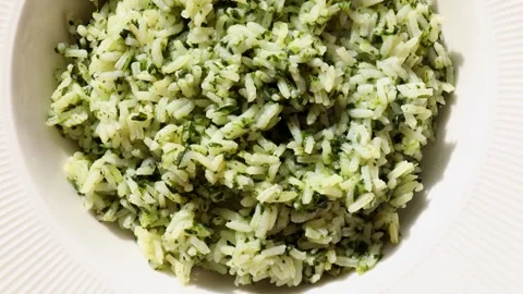 Top view of white plate filled with cooked spinach rice in bright lighting, Stock Footage 310786230