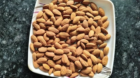 Top view of a white plate filled with fresh raw almonds Stock-Footage 326021543