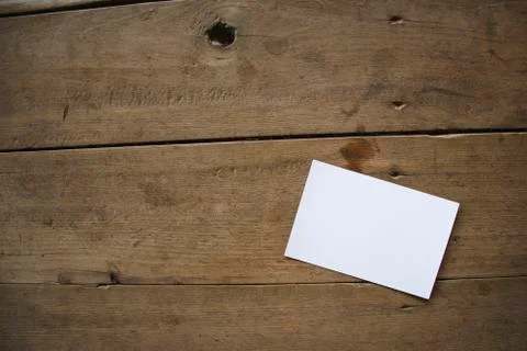 Top view of white postcard or paper on old wooden background Stock Photos