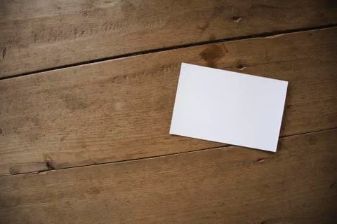 Top view of white postcard or paper on old wooden background Stock Photos