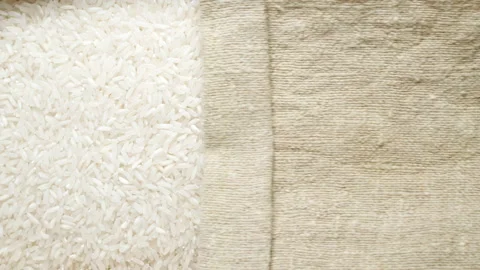 TOP VIEW: White rice under opening sackcloth Stockbeeldmateriaal 171149014
