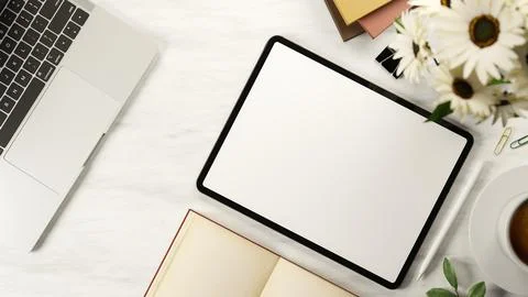 Top view white screen tablet and stylus with book and coffee aside flower a.. Illustrazione stock