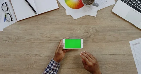 Top view of the white smartphone lying horizontally on the wooden office table Stock Footage 96003437