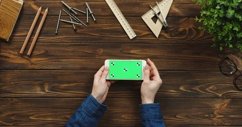 Top view on the white smartphone lying horizontally on the wooden table with Video stock 96174840