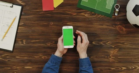 Top view on the white smartphone lying vertically on the wooden table with Stock-Footage 96315896