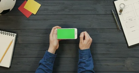 Top view on the white smartphone lying horizontally on the dark grey wooden Stock Footage 96330027