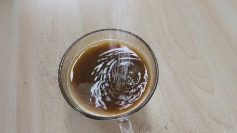 Top View of White Sugar Pouring into Glass Coffee Mug Stock Footage 341908640