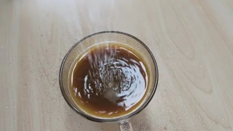 Top View of White Sugar Pouring into Black Coffee Mug 動画素材 342231311