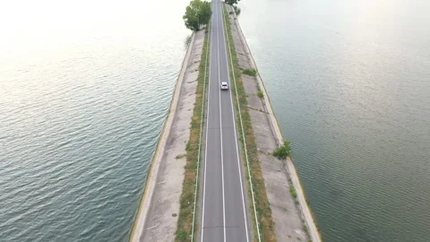 Top view of white SUV driving at dam route. Auto moving through bridge of river Stock Footage 182383367