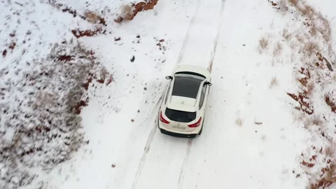 Top view of a white SUV driving on a snowy mountain road Stock Footage 269097475