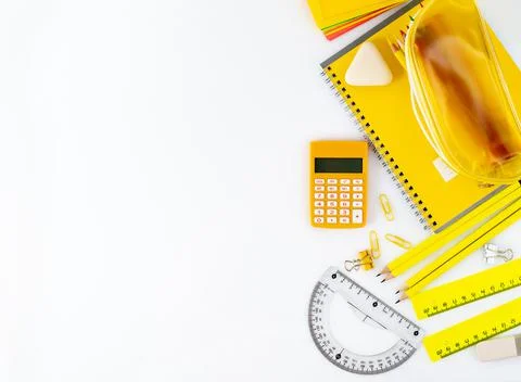 Top view of white table with school supplies on table around empty space for Stock Photos