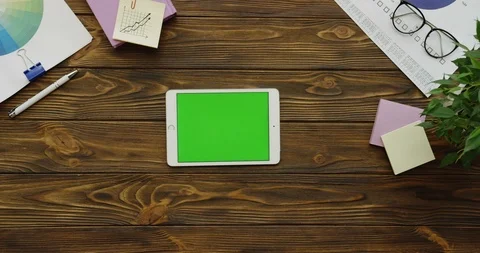 Top view on the white tablet computer with a green screen lying horizontally on Video stock 88388475
