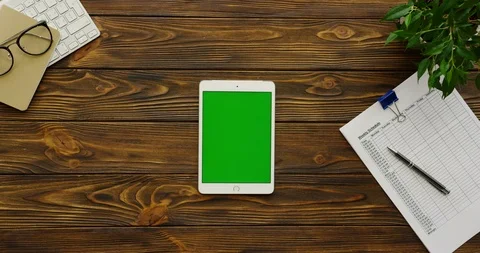 Top view on the white tablet computer with a green screen lying vertically on Video stock 88429214