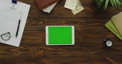 Top view on the white tablet device with a green screen lying horizontally on Stock Footage 88401541