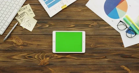 Top view on the white tablet device with a green screen lying horizontally on Stock Footage 88424758