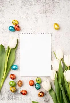 Top view of white tulips, blank calendar and colored easter eggs on concrete  Stock Photos
