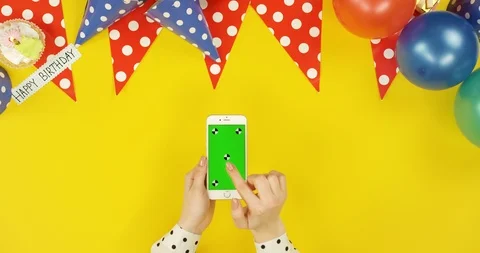 Top view on the white vertical smartphone on the yellow table with birthday 스톡 동영상 89316152