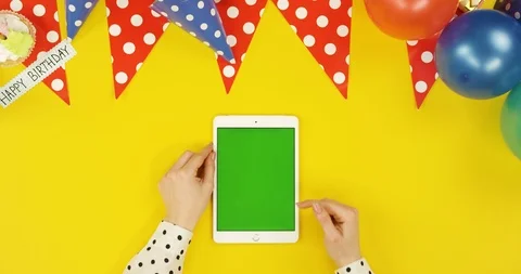 Top view on the white vertical tablet on the yellow table with birthday Stock Footage 89317366