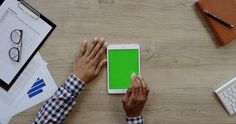 Top view on the white vertical tablet device on the wooden light desk and Stock Footage 96015187