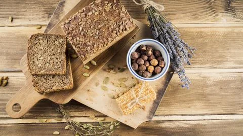 Top view whole grain bread hazelnut bowl with protein bar chopping board. High Stock Photos