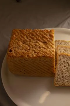 Top view whole grain bread loaf with sliced pieces on white plate Stock Photos