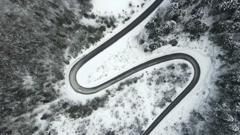 Top view of a winding mountain road that passes through a snow-covered forest. 2 Stock Footage 148112000