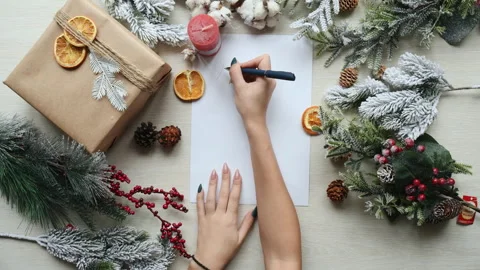 Top view of winter holiday composition. Girl writes Merry Christmas Stock Footage 304424198