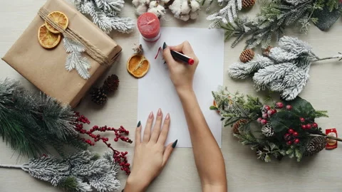 Top view of winter holiday composition. Girl writes Merry Christmas Stock Footage 304425029