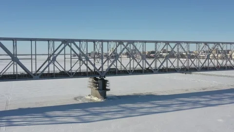 Top view in the winter on the iron bridge and a city through the frozen river. Stock Footage 164546202
