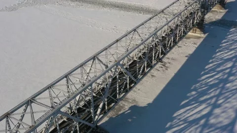 Top view in the winter on the iron bridge and a city through the frozen river. Stock Footage 164546728