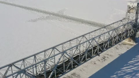 Top view in the winter on the iron bridge and a city through the frozen river. Stock Footage 164678631