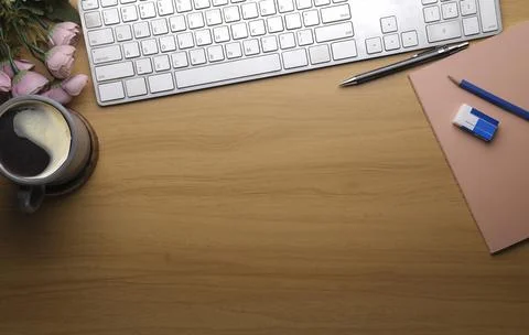 Top view wireless keyboard, coffee cup and stationery on wooden table. Simple Stock-Fotos