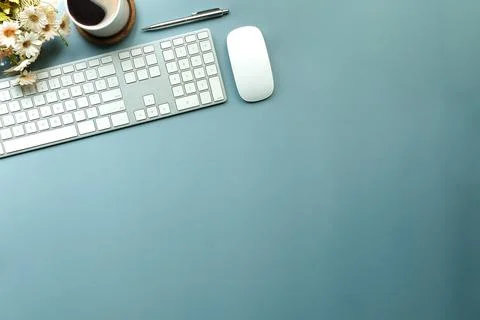 Top view, wireless keyboard, mouse and coffee cup on blue background with cop Stock Photos
