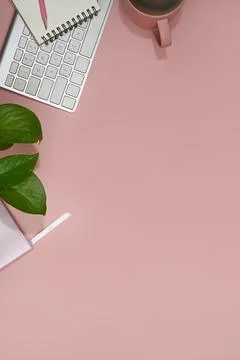 Top view wireless keyboard, notebook, coffee cup and potted plant on pink Stock Photos