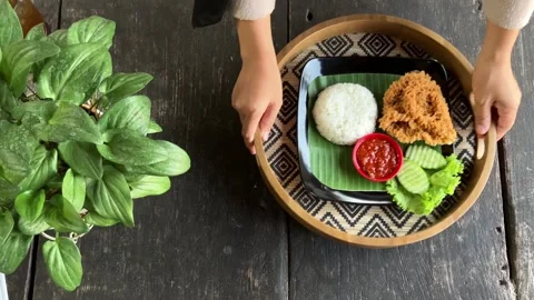 Top View of Woman Hand Serving a Plate of Fried Chicken with Rice 4K Stockbeeldmateriaal 337721020
