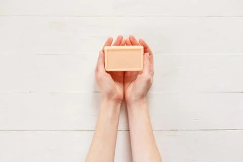 Top view of woman hands with solid soap on white wooden background. 스톡 사진