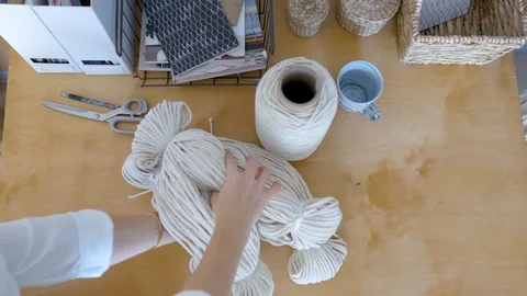 Top view of a woman spreading macrame rope on a table Stock Footage 120980179