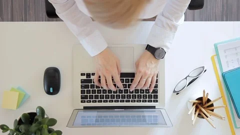 Top view of a woman typing quickly on a laptop in office. Stock Footage 79657661