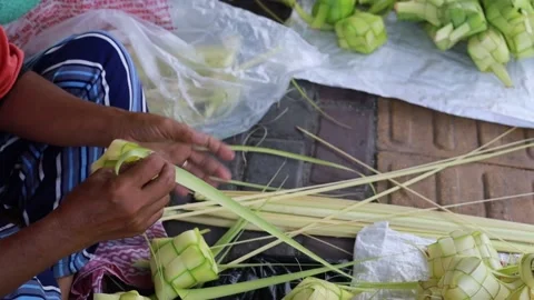 Top view of Woman's hand making ketupat rice cake using palm leaf for eid Video stock 239064450