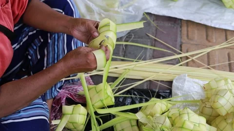 Top view of Woman's hand making ketupat rice cake using palm leaf for eid Video stock 239064533