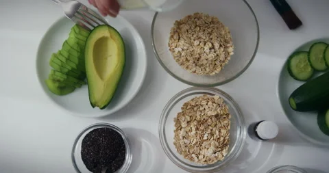 Top view of woman's hand pouring milk into oats bowl making organic scrub face Video stock 148780060