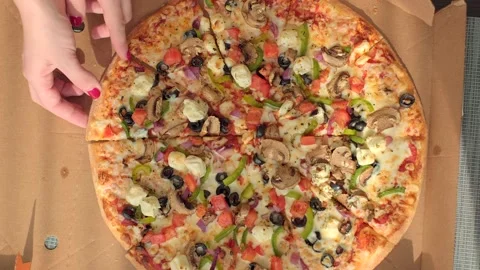 Top view. Woman's hand is taking a piece of pizza on the table. Food concept Stock Footage 194227416