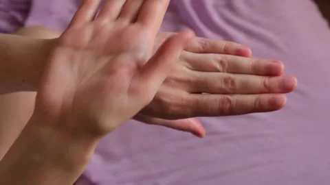 Top view of a woman's hands applying moisturizing cream to care for her skin. Stock Footage 329742600