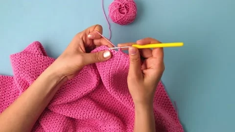 Top view of woman's hands crocheting with cotton yarn on white background Stock Footage 239745972
